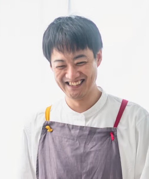 エプロン姿で笑う久保崇裕